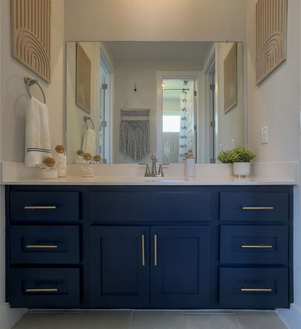 Navy blue bathroom cabinets with gold pulls and TaylorCraft's Shaker cabinet doors in OE4, IE2, Flat panel with gold pulls