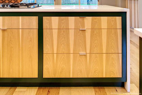 Modern edgebanded slab veneer hickory drawer fronts book and bank matched with adjacent cabinet doors