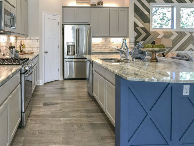 Kitchen with blue island back and light gray perimeter cabinet doors