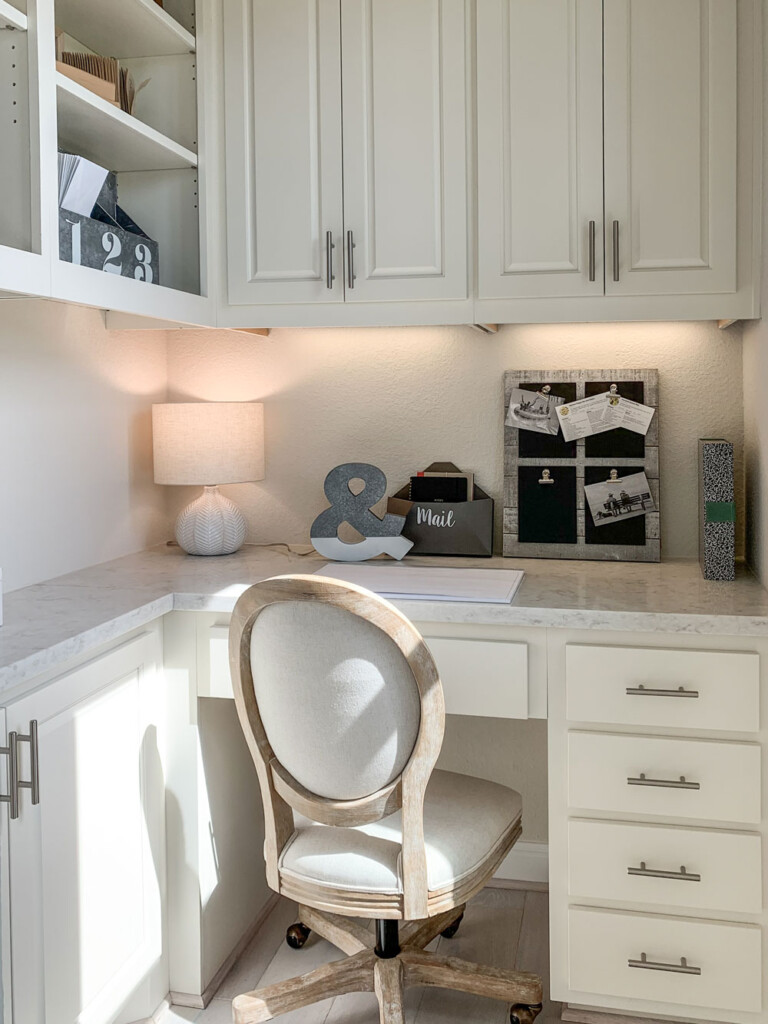 Hidden corner office built-in desk with paint grade raised panel cabinet doors in warm white