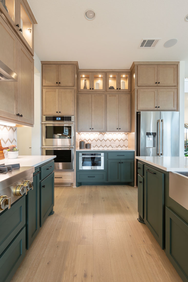 Kitchen with natural, light stained maple uppers and green painted base cabinets with Shaker OE4, IE2 flat panel doors