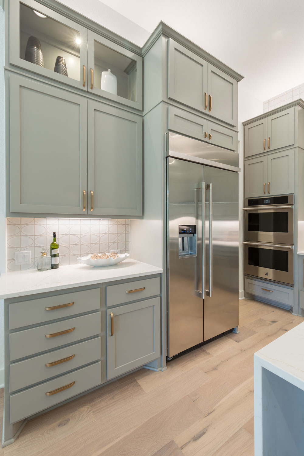 Grey green kitchen cabinets with paint grade shaker doors in OE4 IE2 with flat panel and gold hardware