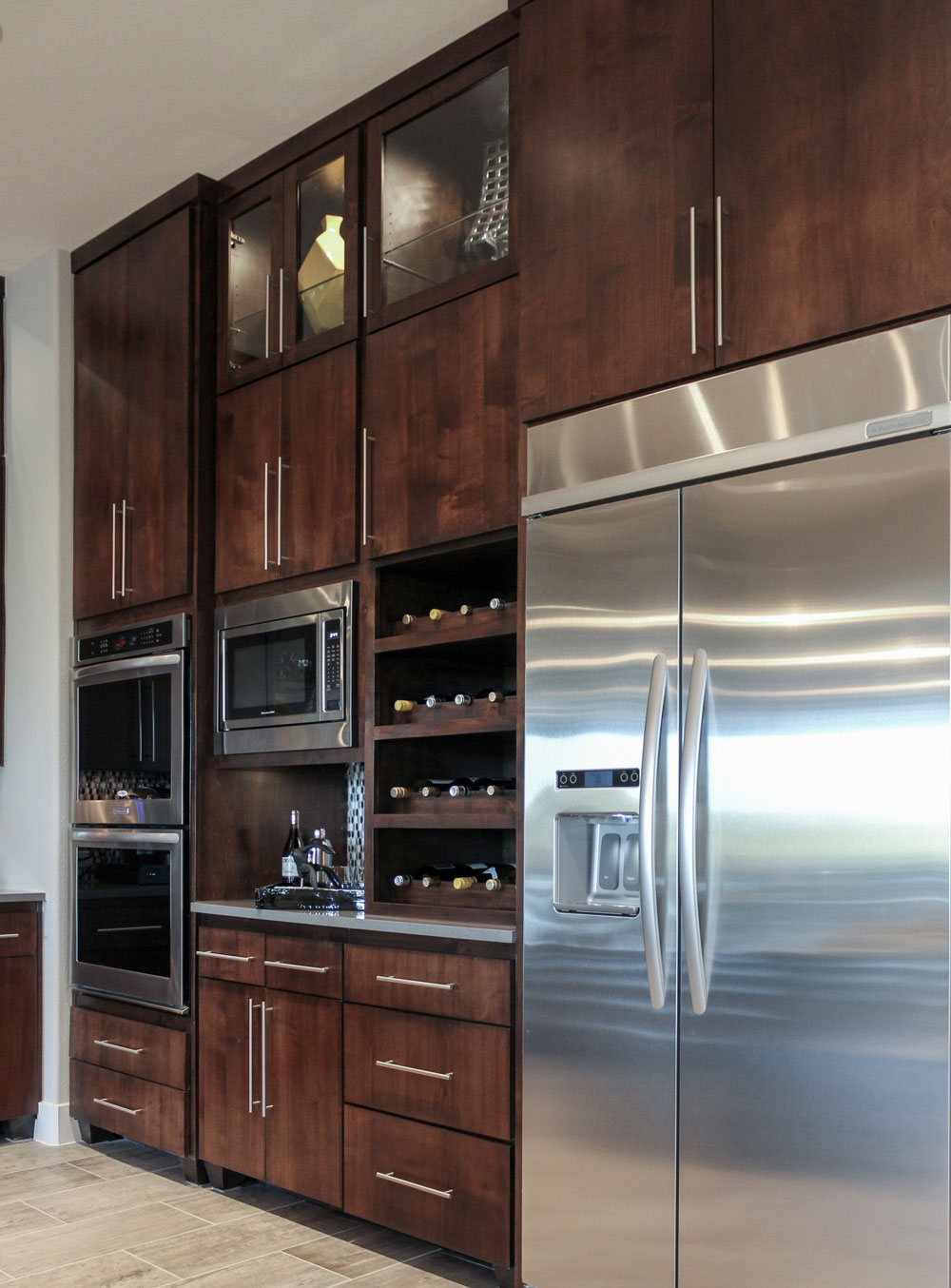 Modern kitchen cabinets with slab edgebanded doors in alder, glass uppers and built in wine storage