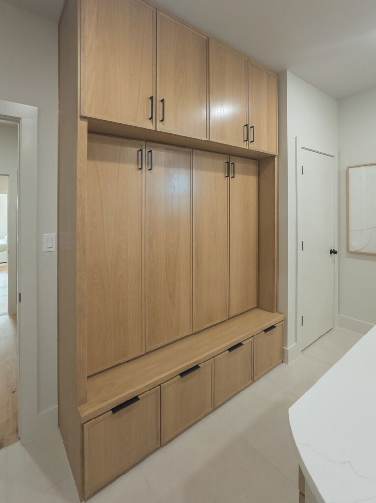 Built-in white oak mud room cabinets with hidden coat and shoe storage and 4S cabinet doors
