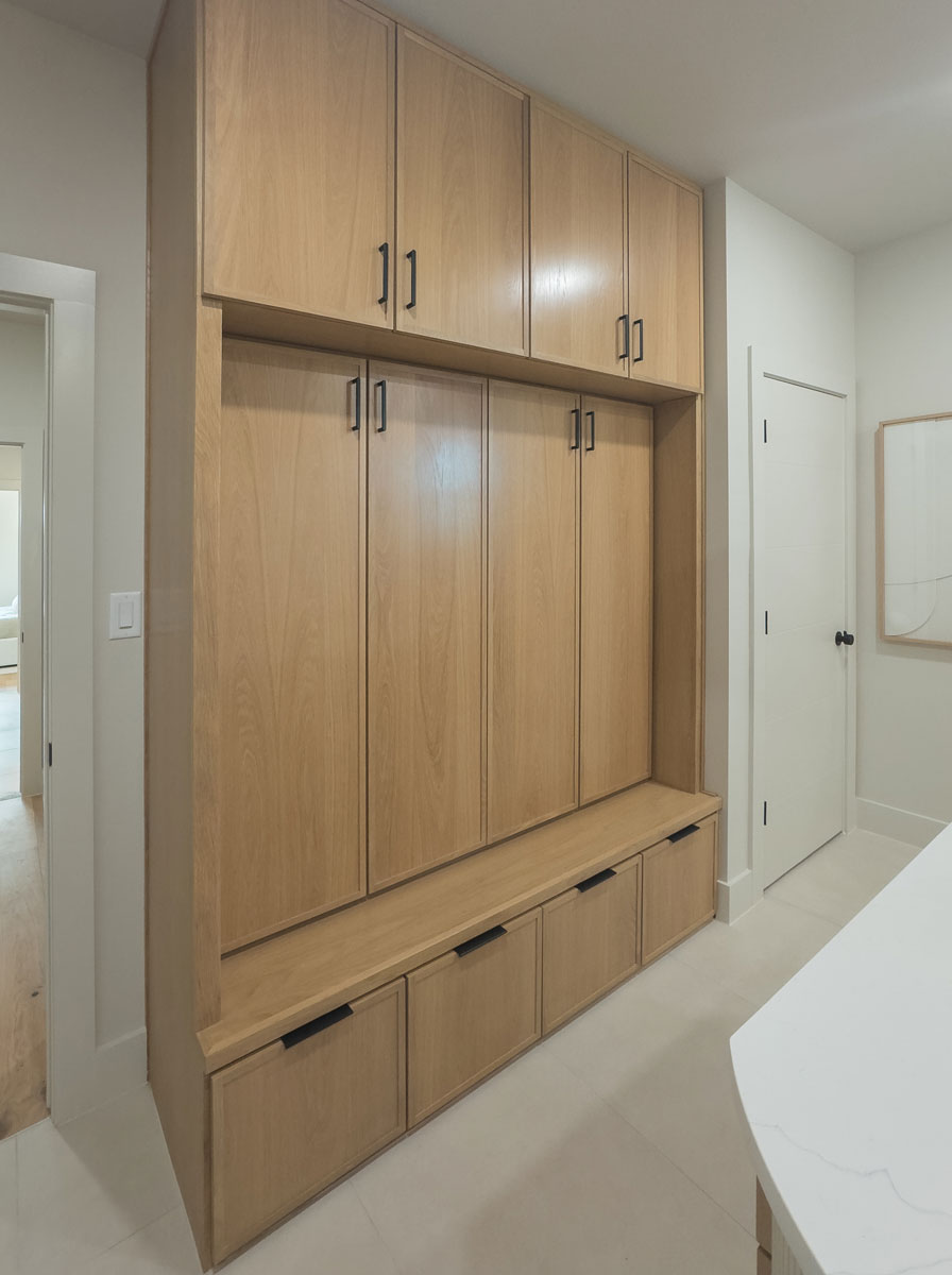 Built-in white oak mud room cabinets with hidden coat and shoe storage and 4S cabinet doors